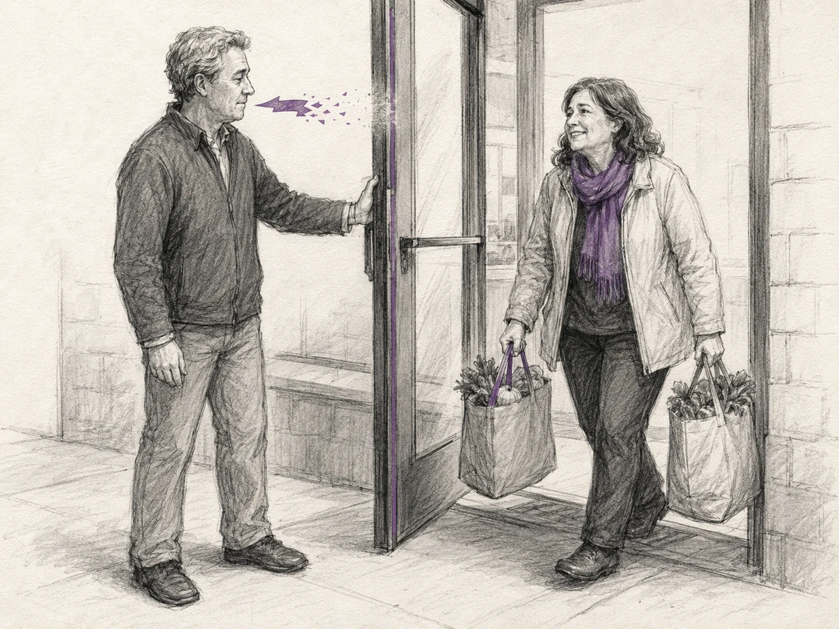 A person chooses to hold a door for someone struggling with bags instead of speaking harshly.